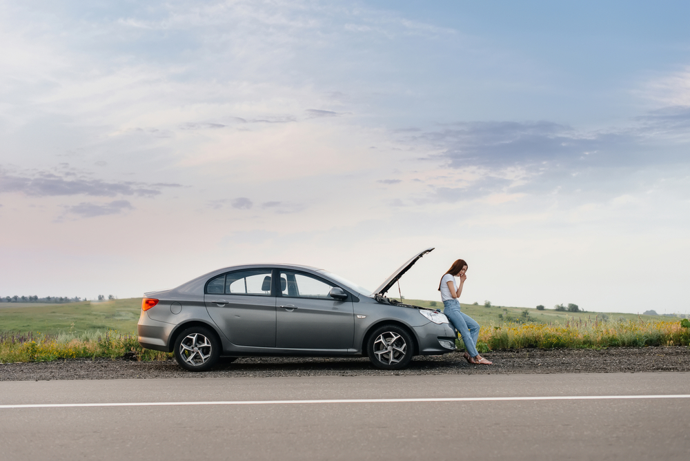 A,Frustrated,Young,Girl,Stands,Near,A,Broken-down,Car,In